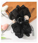 Black claw clip resting on a minimalist bamboo vanity tray