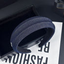 Front view of light blue textured denim headband on white background
