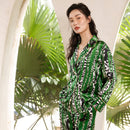 Full-length front view of a woman wearing a long-sleeve silk suit set with an oasis print