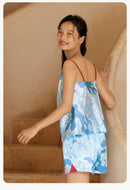 Model smiling while wearing French-style silk pajama set on staircase
