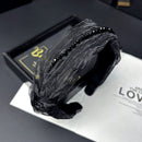 Close-up detail of sparkling rhinestones on black tulle hair band