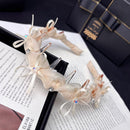 Side angle of satin hair hoop highlighting ruffled texture and smooth satin band