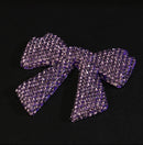 Rhinestone bow next to measuring tape showing approximate 1 inch width