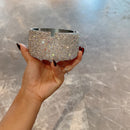 Ashtray placed on mid-century side table with potted plant in background