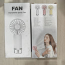 Fan operating with visible fine mist spray against soft natural lighting