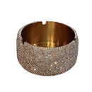 Stainless steel ashtray in gold finish displayed beside ceramic mug and notebook