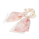 Black bow hair tie styled with half-up hairstyle and delicate earrings