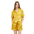 Side angle of gold silk pajama top with button-front detail