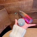 Tumbler resting on gym towel with water bottle and headphones nearby