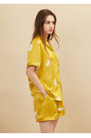 Flat lay of gold silk pajama set with folded shorts