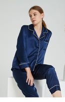 Close-up of deep navy silk pajama top showing button closure and lapel piping