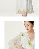 Model in flowing silk robe with white poppy floral accent