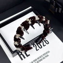 Front view of black velvet crystal headband on white background