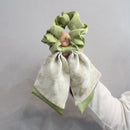 Black satin ribbon bow hair tie with textured fabric base side detail