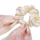 Green bow hair tie wrapped around wrist showing stretch and flexibility