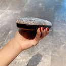 White eyeglass case held in hand to demonstrate compact size and lightweight feel