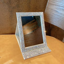 Mirror placed on a dorm desk with laptop and notebook for student lifestyle context