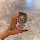 White tumbler in hand with sleeve pushed up — emphasizing ergonomics and scale