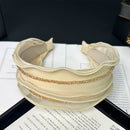 Beige SUUMEE mesh hair band styled on a model's forehead