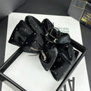 Black velvet bow hair clip styled on medium-length wavy hair