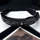 Black rhinestone headband styled on model's hair during skincare routine