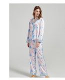 Lifestyle shot of the silk pajama set draped over a chair in a bedroom setting