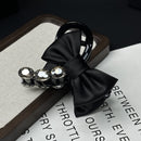 Ribbon bow claw clip in matte black on white background, front view