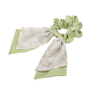 Back view of model wearing green bow hair tie with soft shoulder-length hair