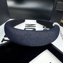 Pearl denim headband styled on model with low bun hairstyle