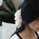 Rose cloud tulle hair clip styled in a low half-up bun on model