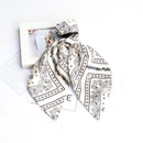 Cashew print hair accessories in soft shadow lighting minimalist composition