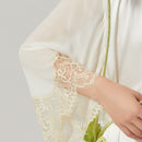 Side view showing flowy bell sleeve and lace hem of silk robe