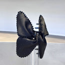 Front view of black satin bow claw clip on white background