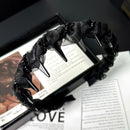 Front view of SUUMEE wave-shaped satin hair band with crystal accents on white background