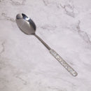 Mirror-polished stainless steel surface reflecting soft studio lighting — texture and shine detail