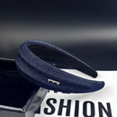 Side angle showing raised texture and structured crown height of denim headband
