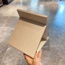 Mirror in use on a bathroom counter with towel and perfume bottle nearby