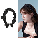 Front view of rose-embroidered ruffled hairband on white background