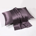 Charcoal gray silk pillowcase draped over pillow on white background