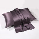Charcoal gray silk pillowcase draped over pillow on white background