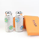 Red tumbler next to fresh flowers and ceramic mug — gift presentation context