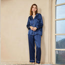 Side view of a woman wearing the silk pajama set while reading