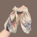 Side angle showing layered bow and flowing ribbon detail of satin hair tie