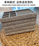 Box placed on bookshelf among hardcover books and succulents