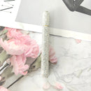 Crystal signature pen placed on a leather desk pad beside business documents