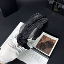 Black tulle hair band worn on model with shoulder-length wavy brown hair, side profile