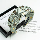 Front view of black ruched rhinestone headband on white background