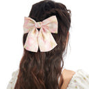 Close-up detail of handcrafted purple bow hairpin with smooth metal clip and layered fabric texture