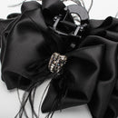 Close-up of prong-set rhinestones centered on black satin bow