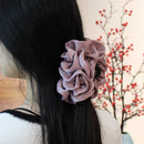 Tulle hair clip held by hand to show lightweight construction